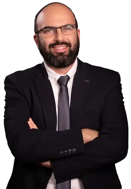 תמונת דיוקן של עו"ד רפאל אוחנה, עורך דין מסחרי, מחייך בבטחה עם ידיים שלובות, לבוש בחליפה ועניבה על רקע אפור בהיר.